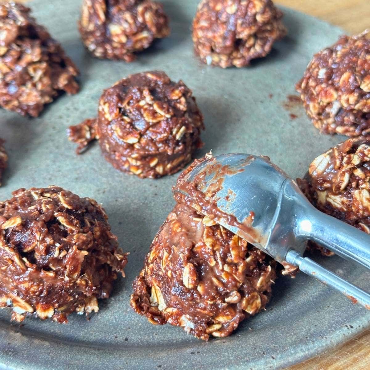 Using a cookie scooper to portion the no-bake cookie dough into balls.