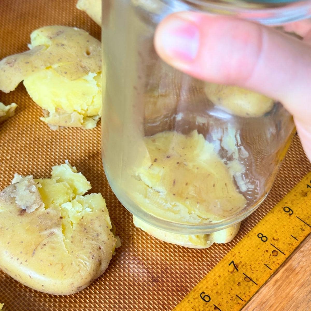 Smashing boiled potatoes with the bottom of a glass jars.